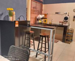 ChemorCASA Singgah Homestay的厨房配有2张吧台凳和1个柜台。