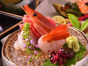 热海古屋旅馆的上面有一盘带虾和蔬菜的食物