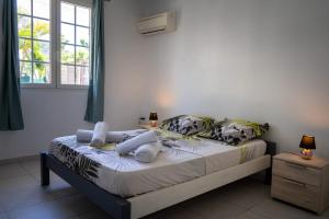 圣安娜La Villa Noémie - Parking - Proche des Plages的一间卧室设有一张床和一个窗口