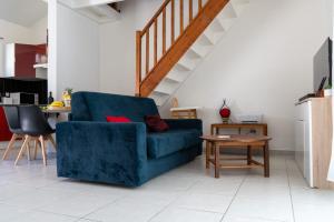 圣安娜La Villa Noémie - Parking - Proche des Plages的客厅配有蓝色的沙发和桌子