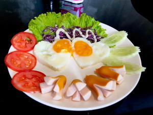 乌隆他尼Kangaroo Residence Udonthani的鸡蛋和沙拉,配上西红柿和生菜