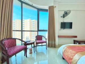 格卢市社海当酒店的酒店客房带床、椅子和窗户