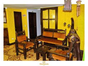 萨兰托HOTEL SHAMBALA的客厅配有椅子和harpsichord