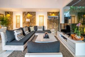 塞米亚克Lotus Luxury Villa Seminyak的带沙发和电视的客厅