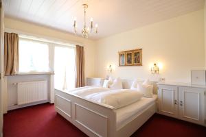 巴特维塞希姆加登宾馆的卧室配有白色的床和窗户。