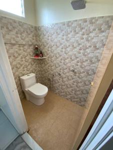PendangAz HOMESTAY PENDANG KEDAH的一间带卫生间和瓷砖墙的浴室