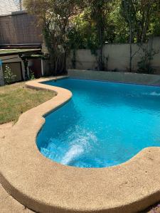 圣地亚哥Agradable casa con piscina, cerca del mall.的一座小型游泳池,四周环绕着一条弯曲的小径