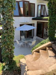 圣地亚哥Agradable casa con piscina, cerca del mall.的一个带蓝伞、椅子和桌子的庭院