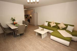 NeuhausAquamarin Ostseetraumsuite 02的客厅配有绿色沙发和桌子