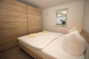 NeuhausAquamarin Ostseetraumsuite 02的一间卧室配有一张带白色床单的床和一扇窗户。