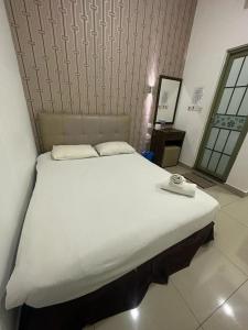 古晋One Point Hotel @ Airport (Kuching)的一张大白色的床,位于带镜子的房间里