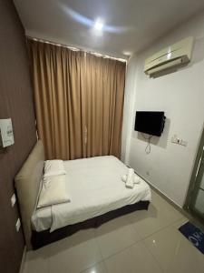 古晋One Point Hotel @ Airport (Kuching)的一间小卧室,配有一张床和电视