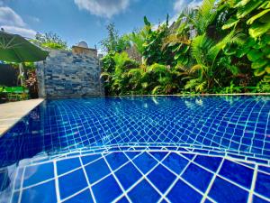 暹粒Bed & Bedzzz的一座拥有蓝色瓷砖地板和植物的游泳池