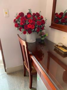 Móng CáiThịnh Nhàn motel的一张桌子上一束红玫瑰花