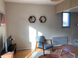 多维尔Studio proche plage balcon et parking的客厅配有桌子、椅子和电视