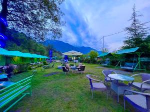 马拉里Himalayan Nature Walk Resort, Manali的一组桌椅和遮阳伞