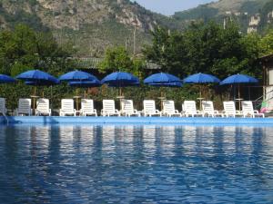 皮雅诺迪索伦托菲奥里达兰希奥酒店的一组椅子和遮阳伞在水边