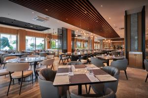 库萨达斯Richmond Ephesus Resort - All Inclusive的餐厅设有桌椅和窗户。
