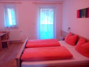圣维吉利奥Prestihof的客厅配有红色枕头的床铺