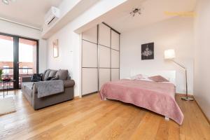 塔林Luxury Suites - Rotermann City的一间卧室配有一张床和一张沙发