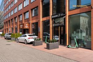 塔林Luxury Suites - Rotermann City的停在大楼前的白色汽车
