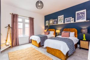达灵顿Boho Chic - Stylish Home in City Centre, Sleeps 4的蓝色墙壁客房的两张床