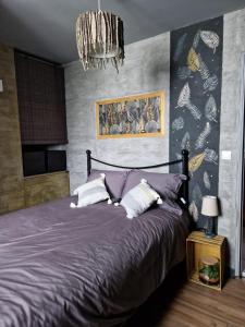 SambinLa Parenthèse的一间卧室配有一张大紫色床和吊灯