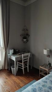 比耶拉In centro da Laura, Via Repubblica 49 BI的一间卧室配有书桌、桌子和床。