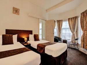 大雅茅斯The Waverley Hotel的酒店客房配有两张床和一张书桌
