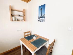 维林根凡妮莎假日公寓的一张餐桌,配有两把椅子和一张墙上的照片