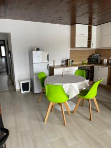 比哈奇Apartment Vila Tara的厨房配有桌子和绿色椅子