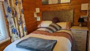 特兹西尼德Snowdonia Log cabin的小木屋内一间卧室,配有一张床