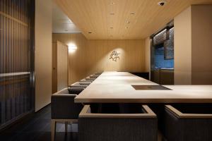 京都Agora Kyoto Karasuma的一间会议室,配有长桌子和椅子
