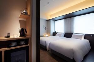 京都Agora Kyoto Shijo的酒店客房设有两张床和壁炉