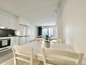 万塔Easy Stay Room near Airport的白色的厨房配有白色的桌子和椅子