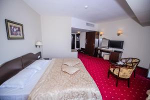 图尔恰埃斯普拉纳达酒店的酒店客房设有一张大床和一张书桌。