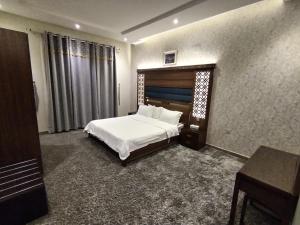 海米斯穆谢特امارلس للشقق الفندقية的卧室配有白色的床、桌子和书桌