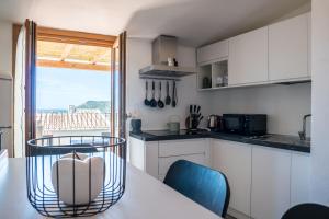 博萨Belvedere - Terrazza panoramica的厨房配有白色橱柜和桌椅