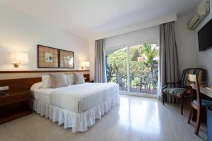 Estepona彼德拉帕洛玛酒店的一间带白色床的卧室和一个阳台