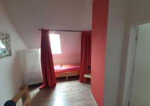 格罗斯内默罗Haus Seenplatte的一间设有红色床和窗户的客房