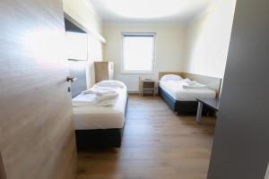 施韦夏特Das Reinisch Just Rooms的小房间设有两张床和窗户