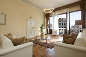 威尼斯里亚托城市公寓的客厅配有白色家具和大窗户