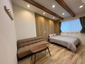 大阪蝉時雨－大正的一间卧室配有一张床、一张沙发和一张桌子