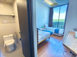 关丹Riverbank Kuantan by Glex的一间卧室设有一张床、一个卫生间和一个窗口