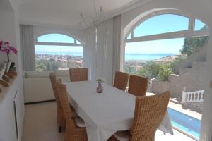 马拉加Villa Seaview Suncoast Luxury的一间配备有白色桌椅的用餐室