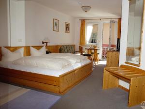 托特瑙Landgasthaus Kurz Hotel & Restaurant am Feldberg - Schwarzwald的一间卧室配有一张大木床和白色床单