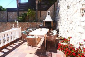 马拉加Villa Seaview Suncoast Luxury的庭院配有木桌、椅子和鲜花