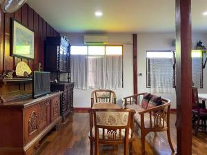 清莱GrandmaD的客厅配有桌椅和电视。