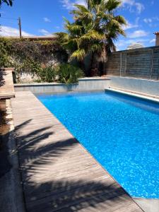 卢贝新城2 pièces rez-de-jardin dans maison avec piscine的一座蓝色的游泳池,旁边是木道