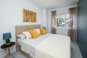 比奥格勒·纳·莫鲁Villa Unica的卧室配有一张带黄色枕头的大型白色床。